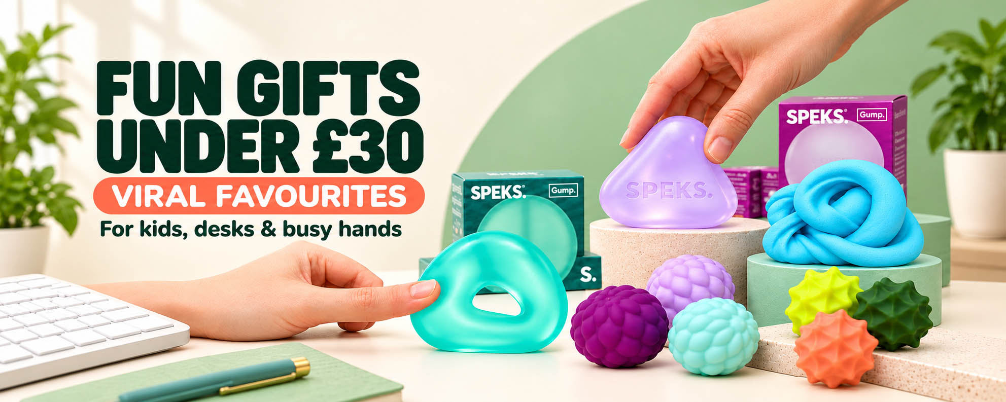 A promotional banner for SPEKS stress-relief toys showing colorful textured toys and packaging on a desk with hands interacting with the products. Large text reads 'FUN GIFTS UNDER £30 VIRAL FAVOURITES For kids, desks & busy hands'. https://www.bumbleliving.co.uk/collections/gifts-under-30