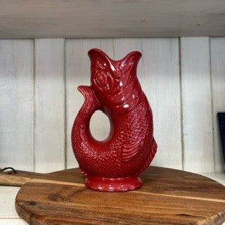 Mini cranberry-colored Gluggle Jug by The Gluggle Jug Factory, featuring a classic ceramic design with a built-in spout and decorative handle.