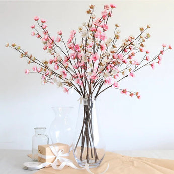 Artificial Japanese pink cherry blossom spray with a single stem, featuring vibrant pink blossoms and green leaves.