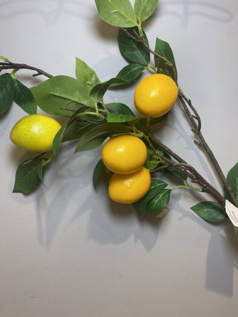 Artificial lemon branch by Lotus Imports Ltd, 85cm long with realistic yellow lemon and green leaves, perfect for floral decor.