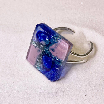 Pink and blue handcrafted glass ring from Bumble Living, featuring vibrant colors and intricate design, displayed on a neutral background.