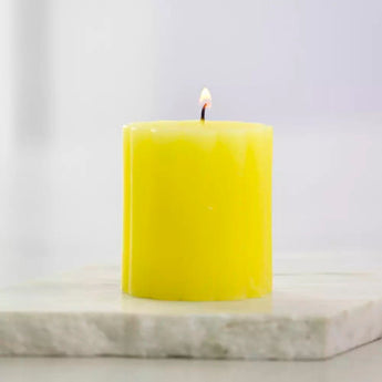 Rustic yellow lemon-scented pillar candle from Grand Illusions, 100x100mm, with textured rustic finish for cozy ambiance.