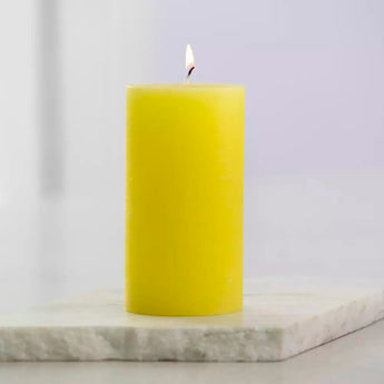 Rustic lemon-colored pillar candle by Grand Illusions, 70x130mm, with textured wax surface and unlit, suitable for home decor.