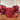 Rustic red pillar candle by Grand Illusions, 100x100mm, with textured surface and warm lipstick red color.