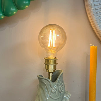 Sage-colored Gluggle Jug lamp with traditional design, featuring a spout and handle, created by The Gluggle Jug Factory.
