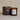 Plum & Ashby smoky birch and oak scented candle in a glass jar with a lit wick, showcasing warm, earthy tones.