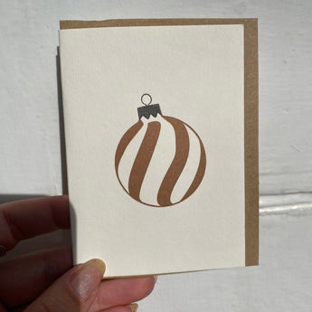 Black and gold spiral bauble greeting card by Penguin Ink featuring festive holiday design and elegant spiral embellishments.