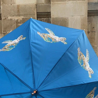 Tom the Turtle umbrella by Emily Smith featuring a colorful turtle design and sturdy canopy for rainy days.