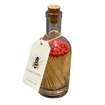 Red matches in a clear glass bottle by Promo Branding, perfect for lighting candles or fires.
