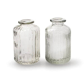 Clear glass bottle vase with a stem design by Casa Verde, featuring a sleek, minimalist style suitable for floral arrangements.