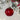 Red diamond-cut glass bauble by Grand Illusions with intricate faceted design, hanging on a silver string.