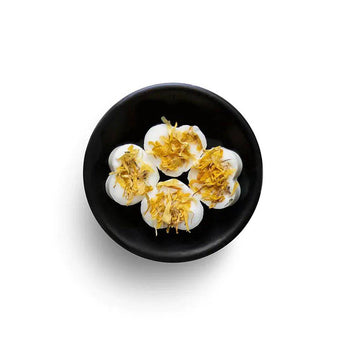Freckleface grapefruit and mangosteen soy wax melts in a clear container, showcasing vibrant colors and fragrant aroma.