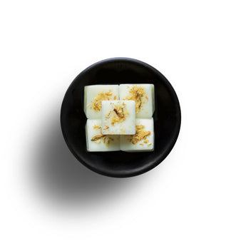 Freckleface Honeysuckle and Jasmine wax melts in a clear container, showcasing the floral-scented wax pieces.