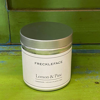 Freckleface Lemon & Pine Tin Scented Candle in a metal container with lemon and pine design.