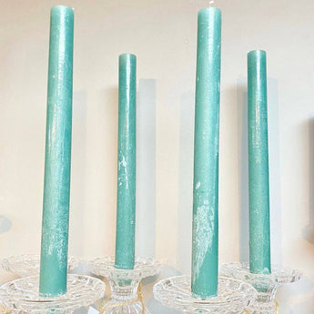 Sea green rustic dinner candle by Grand Illusions, 23x270mm, shown burning in a candle holder for elegant table decor.