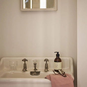 Plum & Ashby Wild Fig and Saffron Hand & Body Wash in a clear bottle with a pump dispenser, featuring a luxurious, aromatic formula.